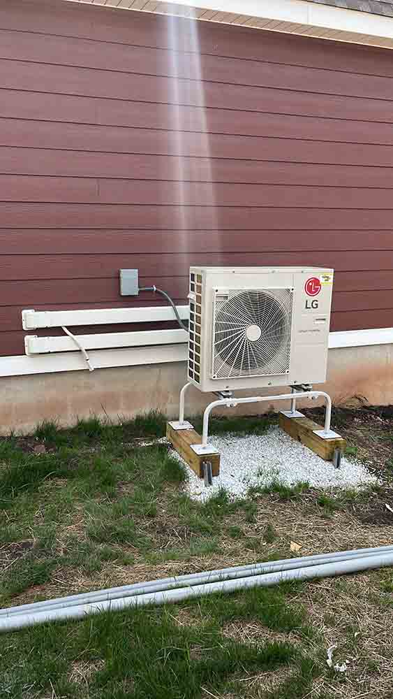 Air conditioning unit installed outside a home, showcasing quality HVAC service by Jeffrey Burke Plumbing, Heating & Cooling, with visible LG branding and clean landscaping.
