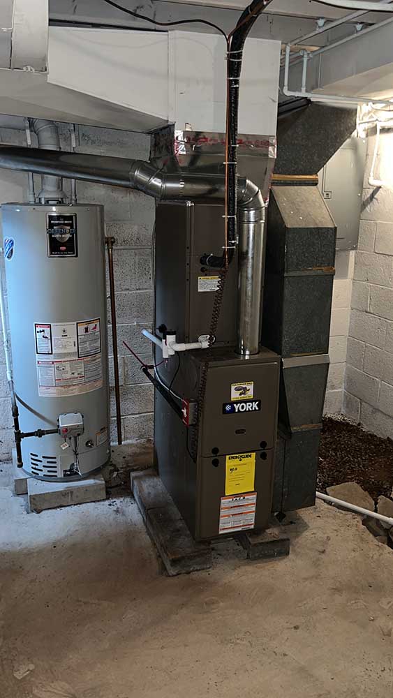 Furnace installation by Jeffrey Burke Plumbing, featuring a York furnace and water heater in a basement setting, showcasing quality heating solutions.
